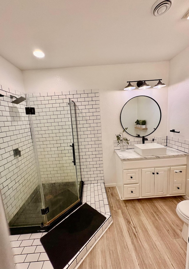 1622 82nd Ave NW, Williams, MN 56686 - full bathroom with vanity, a stall shower, wood finished floors, toilet, and recessed lighting