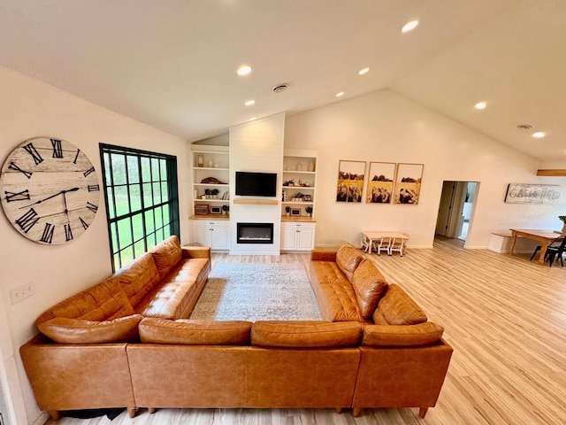 1622 82nd Ave NW, Williams, MN 56686 - living room with vaulted ceiling, recessed lighting, wood finished floors, a glass covered fireplace, and built in shelves