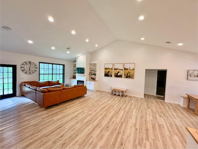 1622 82nd Ave NW, Williams, MN 56686 - living room with lofted ceiling, light wood-style flooring, a fireplace, and recessed lighting