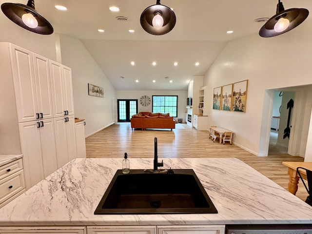 1622 82nd Ave NW, Williams, MN 56686 - kitchen with a sink, open floor plan, light wood finished floors, light stone counters, and high vaulted ceiling