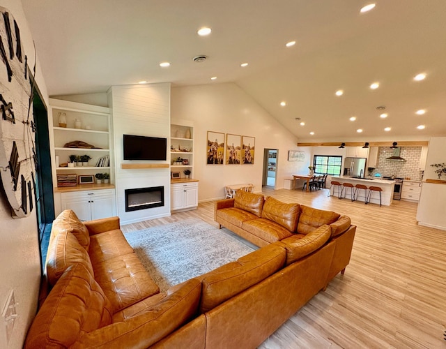 1622 82nd Ave NW, Williams, MN 56686 - living room featuring a large fireplace, vaulted ceiling, light wood-style flooring, recessed lighting, and built in features