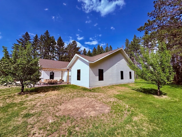 1622 82nd Ave NW, Williams, MN 56686 - view of side of home featuring a yard, a patio, and roof with shingles