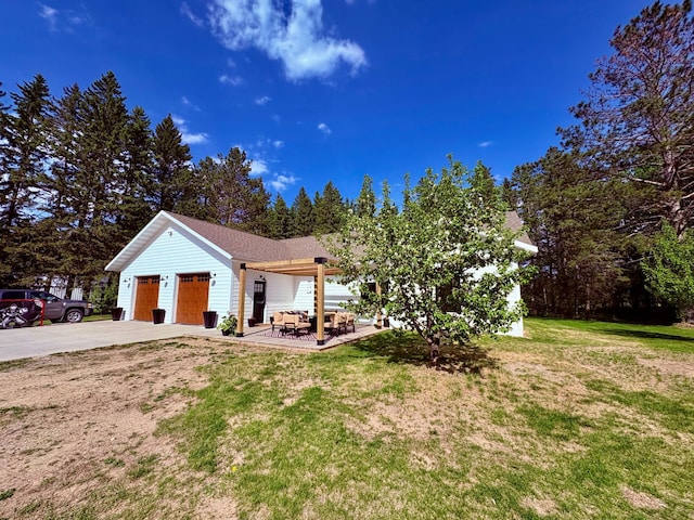 1622 82nd Ave NW, Williams, MN 56686 - view of front facade featuring concrete driveway, a garage, a front yard, outdoor lounge area, and a patio