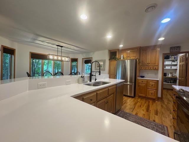 15224 Swallow St NW, Andover, MN 55304 - kitchen featuring a sink, stainless steel appliances, light countertops, brown cabinetry, and recessed lighting