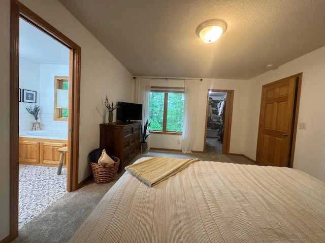 15224 Swallow St NW, Andover, MN 55304 - bedroom with light carpet, a spacious closet, a textured ceiling, connected bathroom, and baseboards