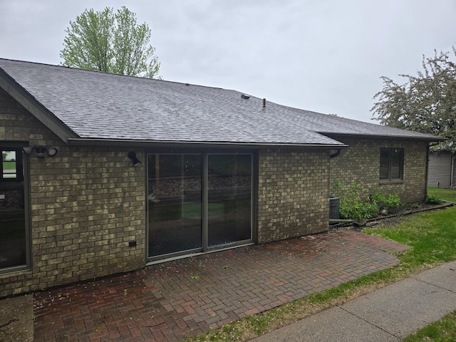 1841 Kemberidge Rd, Detroit Lakes, MN 56501 - back of house with a shingled roof, brick siding, and a patio