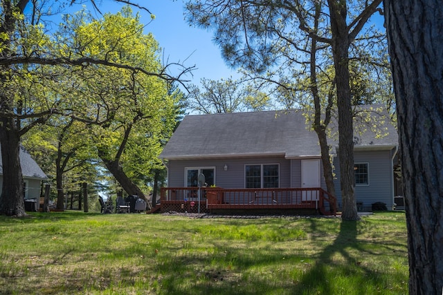 601 Idlewild St Unit 102, Balsam Lake, WI 54810 - rear view of property featuring a deck, a lawn, and a shingled roof