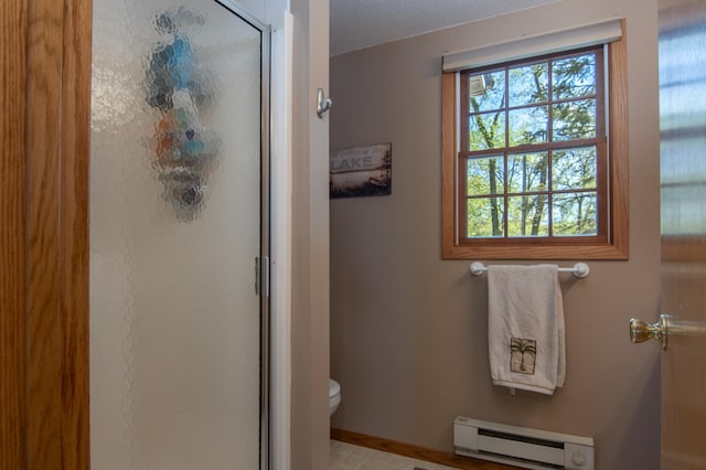 601 Idlewild St Unit 102, Balsam Lake, WI 54810 - full bath with a baseboard heating unit, a shower stall, toilet, and baseboards