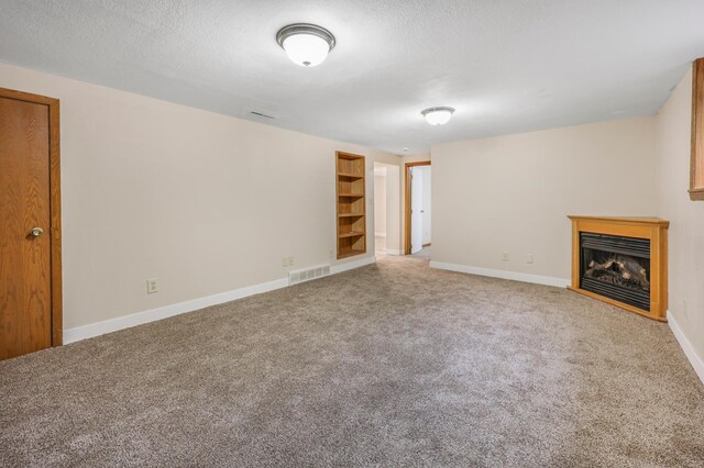 1402 7th St N, Saint Cloud, MN 56303 - unfurnished living room featuring carpet, a fireplace, baseboards, and a textured ceiling