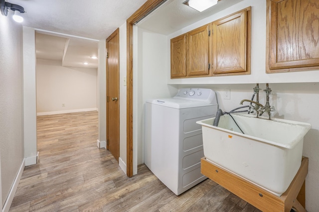 1402 7th St N, Saint Cloud, MN 56303 - laundry room featuring washer / clothes dryer, cabinet space, light wood-type flooring, and baseboards