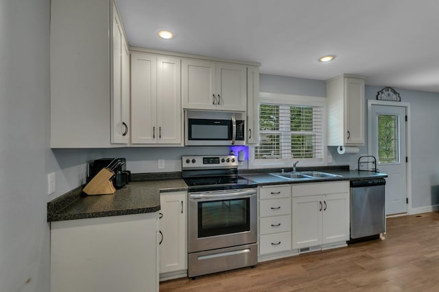 1021 10 1/2 Ave S, Saint Cloud, MN 56301 - kitchen featuring appliances with stainless steel finishes, a sink, dark countertops, white cabinetry, and recessed lighting