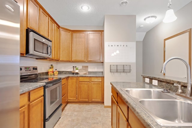 3314 Hazel Trl Unit G, Woodbury, MN 55129 - kitchen with appliances with stainless steel finishes, a sink, a textured ceiling, and decorative light fixtures