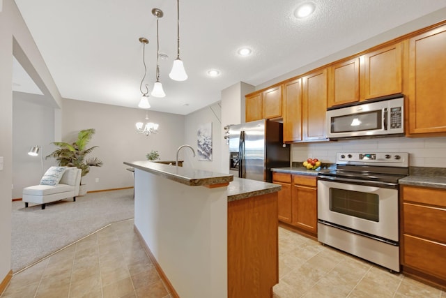 3314 Hazel Trl Unit G, Woodbury, MN 55129 - kitchen featuring appliances with stainless steel finishes, light carpet, a chandelier, dark countertops, and tasteful backsplash