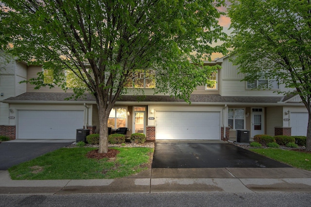 3314 Hazel Trl Unit G, Woodbury, MN 55129 - view of front of house with asphalt driveway, a garage, brick siding, and cooling unit