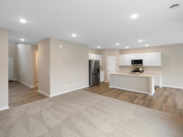 16148 Finale Ave N, Hugo, MN 55038 - kitchen featuring appliances with stainless steel finishes, baseboards, white cabinetry, wood finished floors, and light countertops