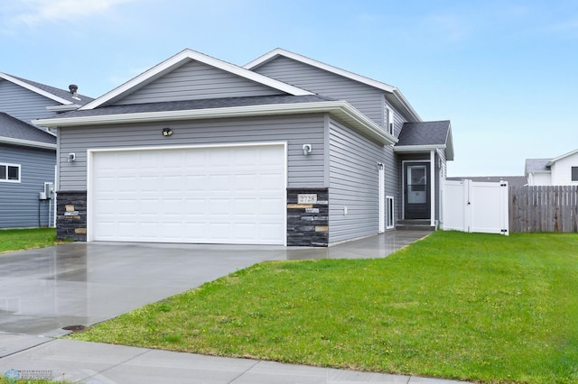 view of front of home featuring stone siding, driveway, a garage, and roof with shingles