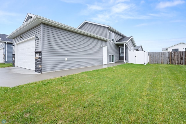 view of home's exterior featuring an attached garage, concrete driveway, and a gate