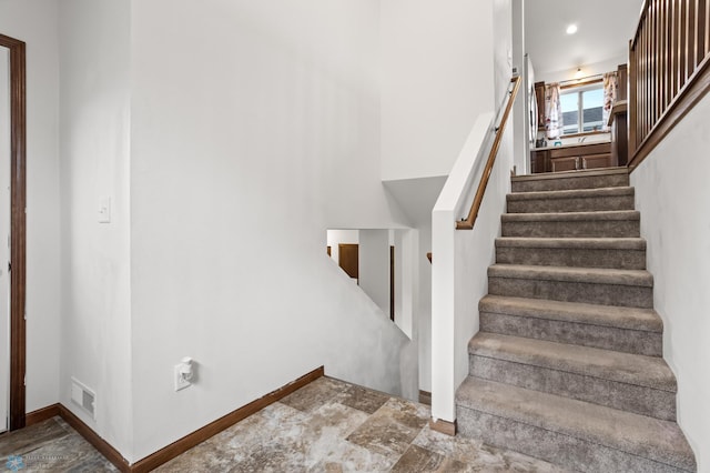 staircase featuring baseboards and stone finish flooring