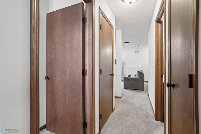 hall with light carpet and baseboards