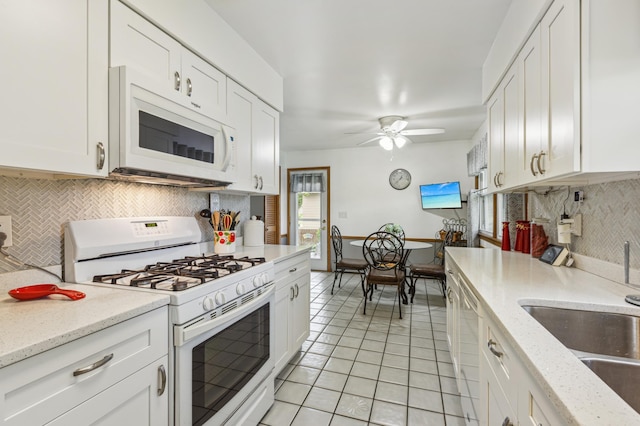 4708 Virginia Ave N, New Hope, MN 55428 - kitchen with white appliances, light tile patterned floors, backsplash, a ceiling fan, and white cabinetry