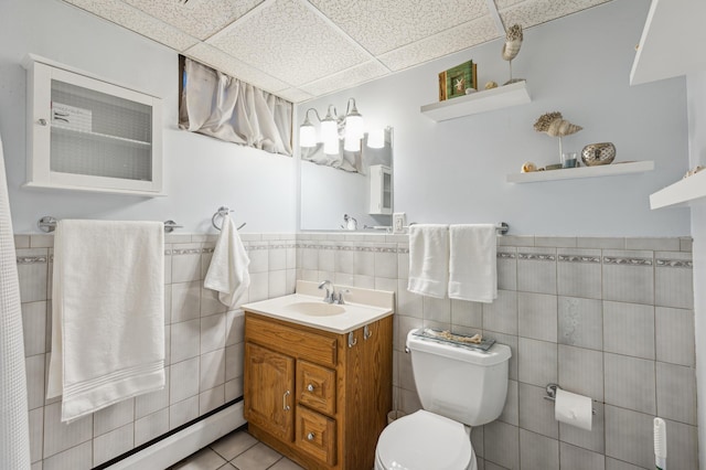 4708 Virginia Ave N, New Hope, MN 55428 - bathroom featuring a paneled ceiling, vanity, tile walls, tile patterned floors, and wainscoting