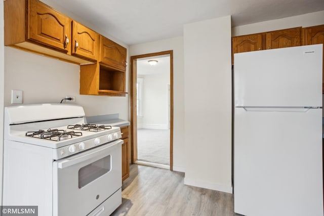 1134 Lincoln St NE, Minneapolis, MN 55413 - kitchen with white appliances, light wood-style floors, brown cabinetry, and light countertops