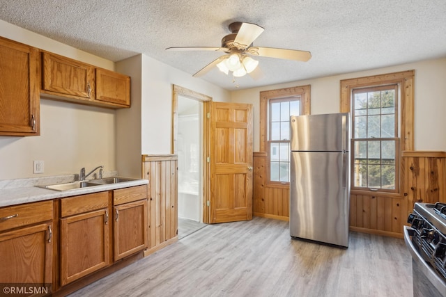 1134 Lincoln St NE, Minneapolis, MN 55413 - kitchen featuring freestanding refrigerator, a sink, gas range oven, light wood-style floors, and wainscoting
