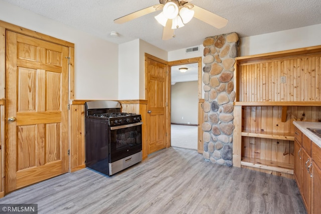 1134 Lincoln St NE, Minneapolis, MN 55413 - kitchen featuring gas range, light wood finished floors, ceiling fan, a textured ceiling, and a wainscoted wall