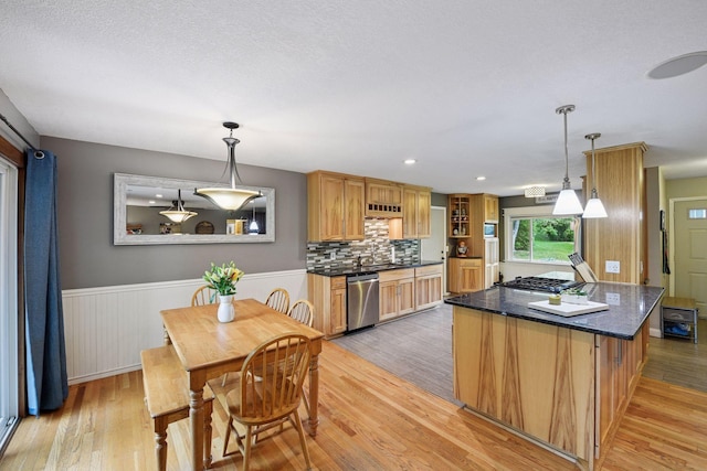 9239 Harbor Ln N, Maple Grove, MN 55369 - kitchen featuring appliances with stainless steel finishes, light wood-style flooring, wainscoting, decorative light fixtures, and backsplash