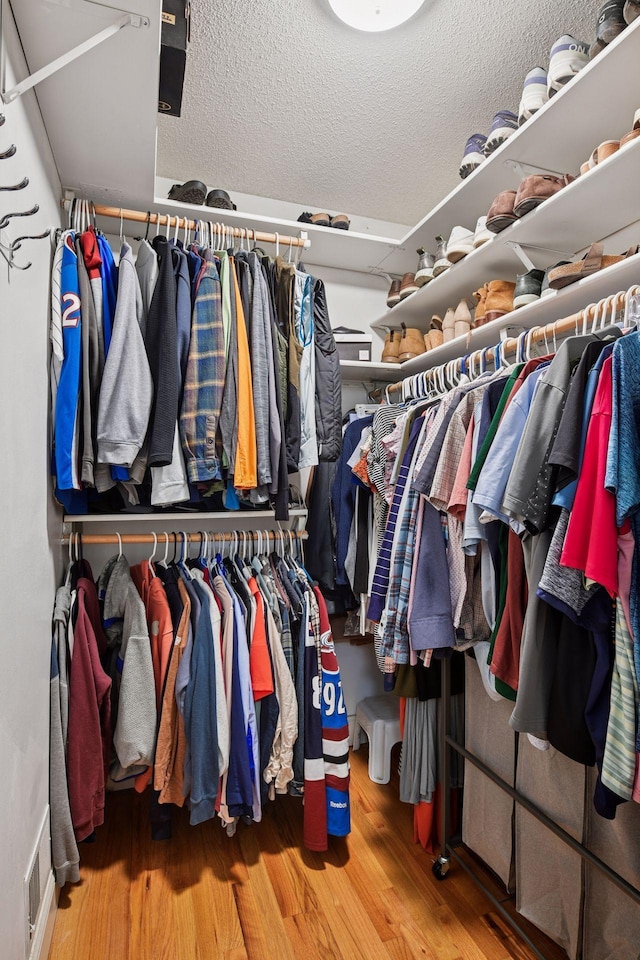 9239 Harbor Ln N, Maple Grove, MN 55369 - walk in closet featuring wood finished floors