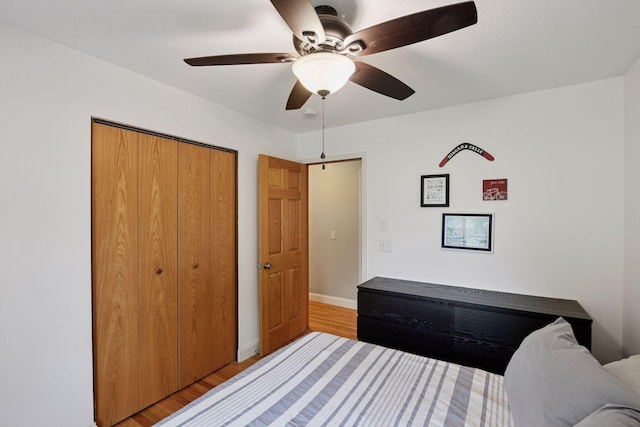9239 Harbor Ln N, Maple Grove, MN 55369 - bedroom with wood finished floors, a closet, baseboards, and a ceiling fan