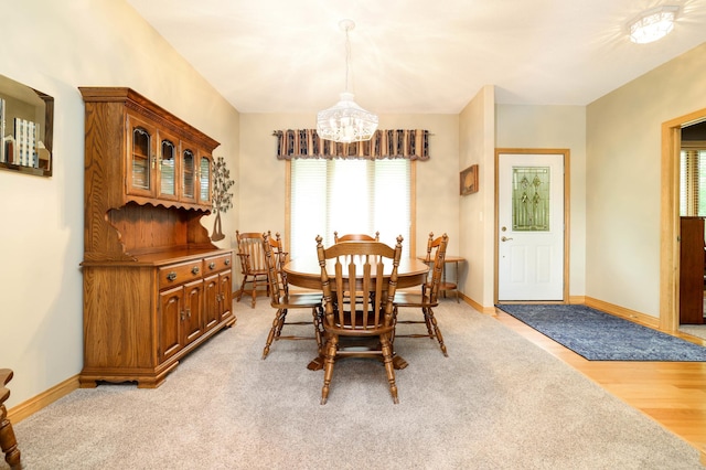 dining space featuring a chandelier, plenty of natural light, and baseboards