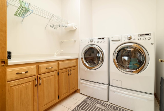 laundry room with washer and dryer, light tile patterned flooring, and cabinet space