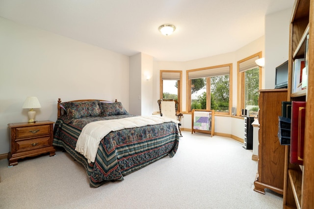 bedroom featuring light carpet and baseboards
