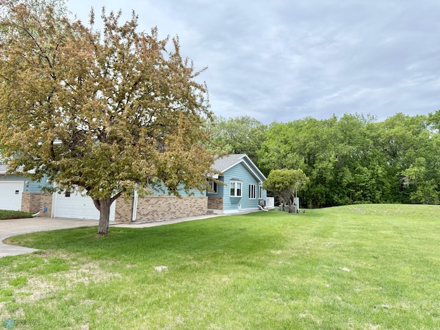 view of front of property with a front yard, concrete driveway, and a garage