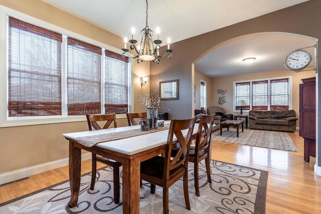 29560 204th Ave, Elizabeth Twp, MN 56537 - dining room with arched walkways, light wood-style flooring, a chandelier, and baseboards