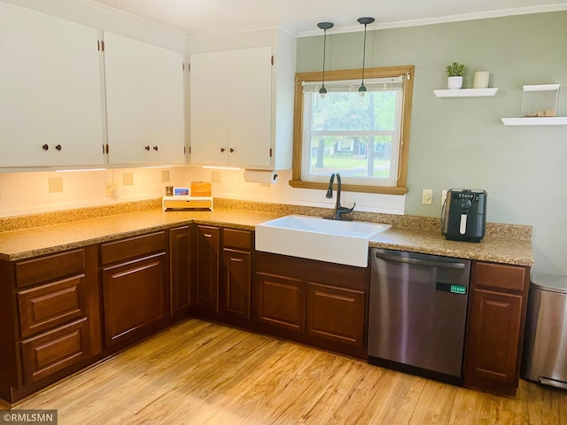 kitchen featuring dishwasher, a sink, white cabinetry, light wood finished floors, and light countertops