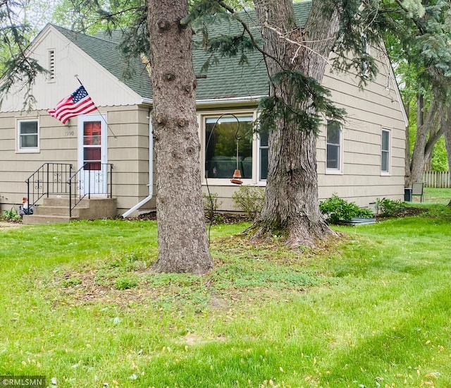 view of front of property featuring a front yard and roof with shingles