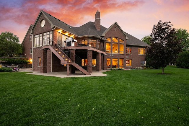 130 Bergamot Dr, Medina, MN 55340 - back of property at dusk with brick siding, a patio, a chimney, and a yard