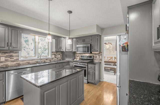 14994 Crane St NW, Andover, MN 55304 - kitchen with gray cabinets, appliances with stainless steel finishes, light wood finished floors, tasteful backsplash, and a textured ceiling