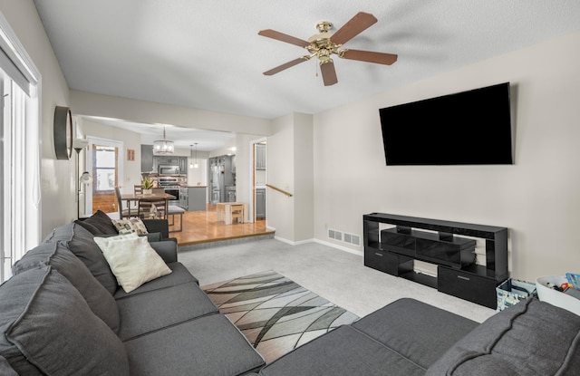 14994 Crane St NW, Andover, MN 55304 - living area with carpet flooring, a ceiling fan, and a chandelier