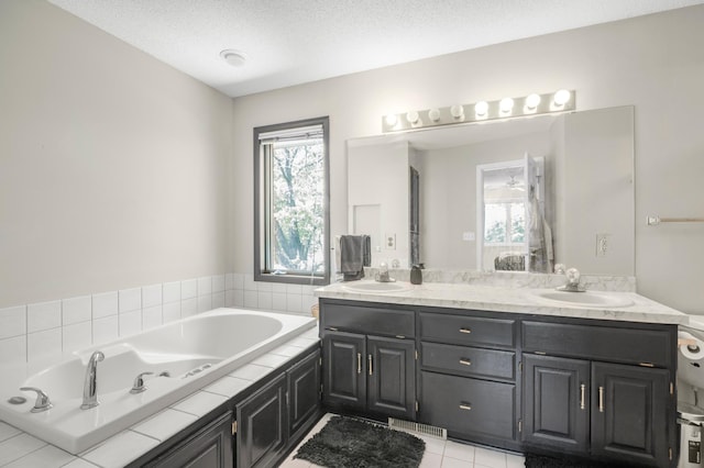 14994 Crane St NW, Andover, MN 55304 - bathroom with double vanity, a tub with jets, healthy amount of natural light, and tile patterned floors