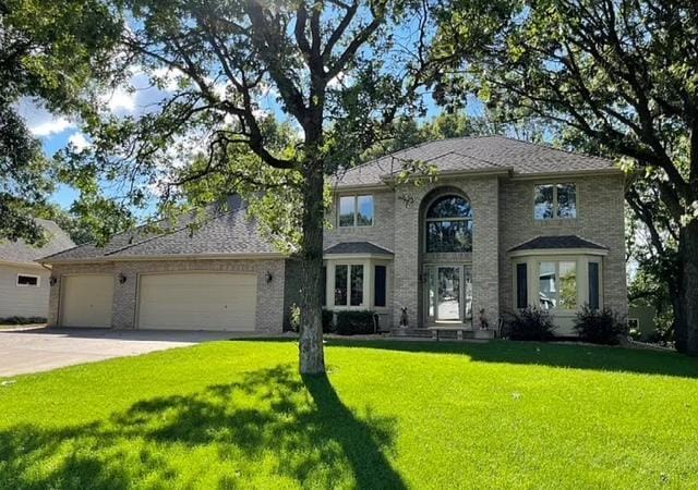 14994 Crane St NW, Andover, MN 55304 - traditional-style home featuring a garage, a front yard, and concrete driveway