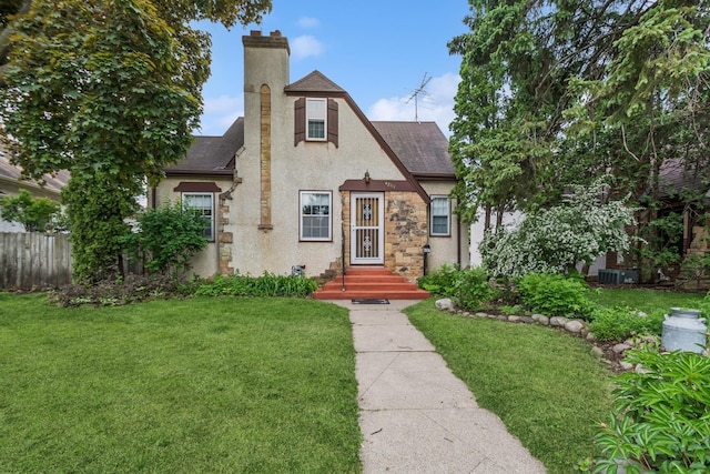 4207 Vincent Ave, Minneapolis, MN 55412 - tudor-style house featuring roof with shingles, stucco siding, a chimney, and stone siding