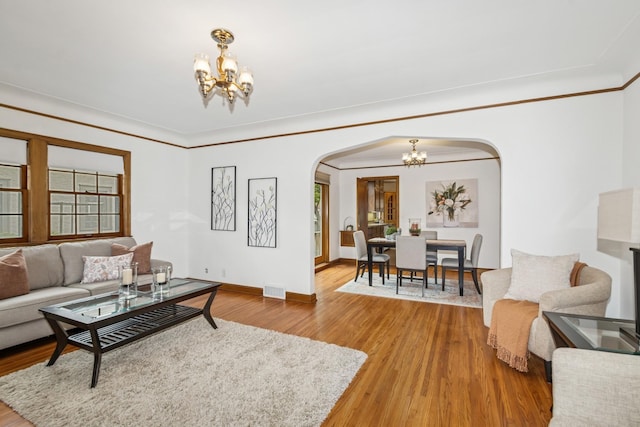 4207 Vincent Ave, Minneapolis, MN 55412 - living area featuring a chandelier, arched walkways, wood finished floors, and ornamental molding