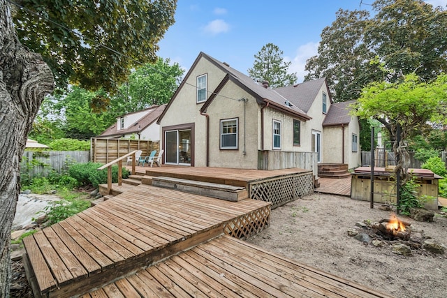 4207 Vincent Ave, Minneapolis, MN 55412 - back of property with an outdoor fire pit, a fenced backyard, a hot tub, stucco siding, and a deck