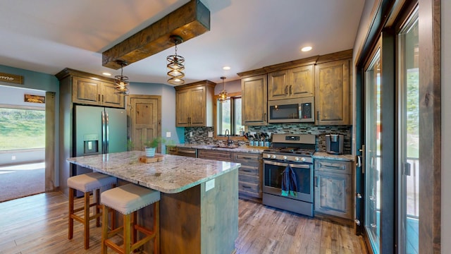 29572 Morgan Rd, Wykoff, MN 55990 - kitchen featuring appliances with stainless steel finishes, a sink, decorative backsplash, a kitchen island, and recessed lighting