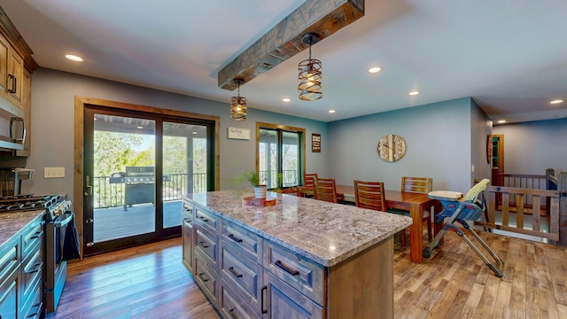 29572 Morgan Rd, Wykoff, MN 55990 - kitchen with stainless steel appliances, light wood-style flooring, light stone countertops, a kitchen island, and recessed lighting