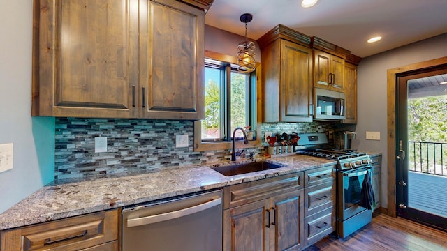 29572 Morgan Rd, Wykoff, MN 55990 - kitchen featuring appliances with stainless steel finishes, a sink, dark wood-style flooring, light stone countertops, and decorative backsplash