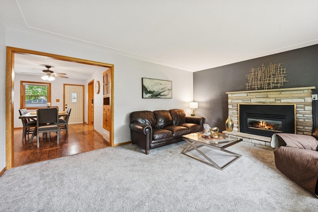 621 Irving Ave NW, Elk River, MN 55330 - living room featuring carpet flooring, a stone fireplace, baseboards, wood finished floors, and ceiling fan
